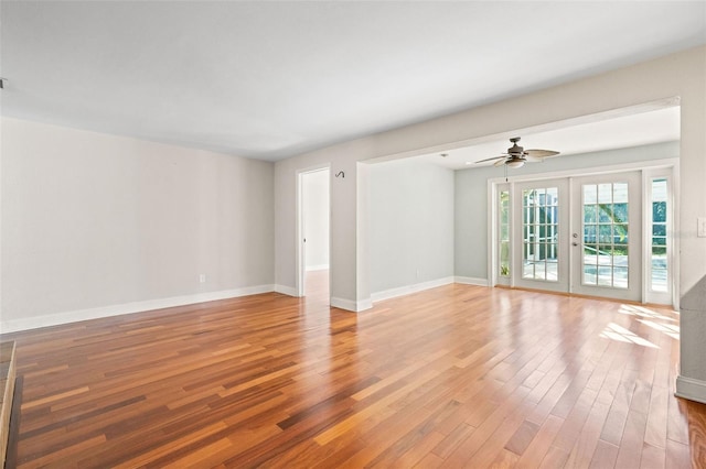 unfurnished room with hardwood / wood-style floors, ceiling fan, and french doors