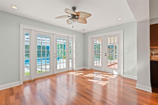 doorway with french doors, light hardwood / wood-style flooring, ceiling fan, and sink