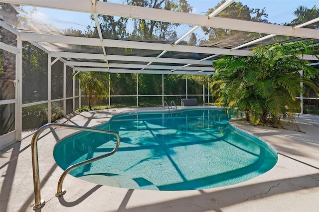 view of pool with glass enclosure and a patio area