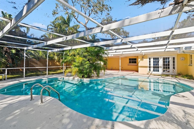 view of pool with glass enclosure, french doors, and a patio