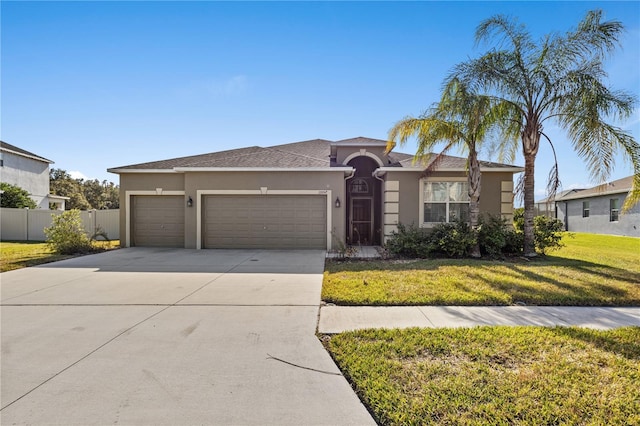 view of front of property with a front yard and a garage