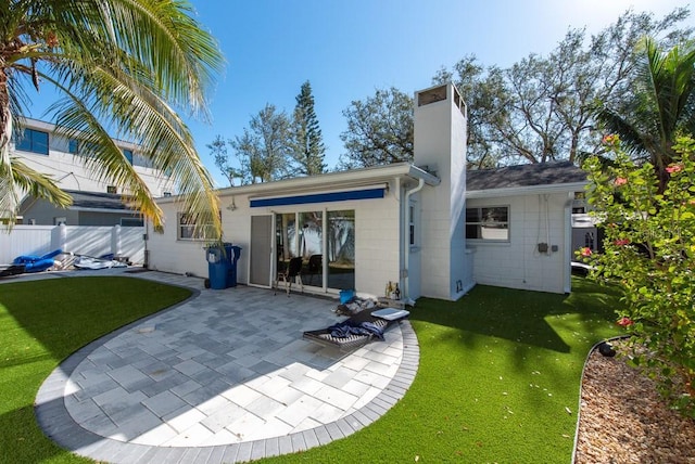 rear view of house with a yard and a patio