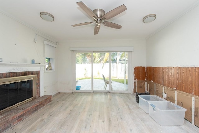 interior space with ceiling fan, ornamental molding, light hardwood / wood-style floors, and a brick fireplace