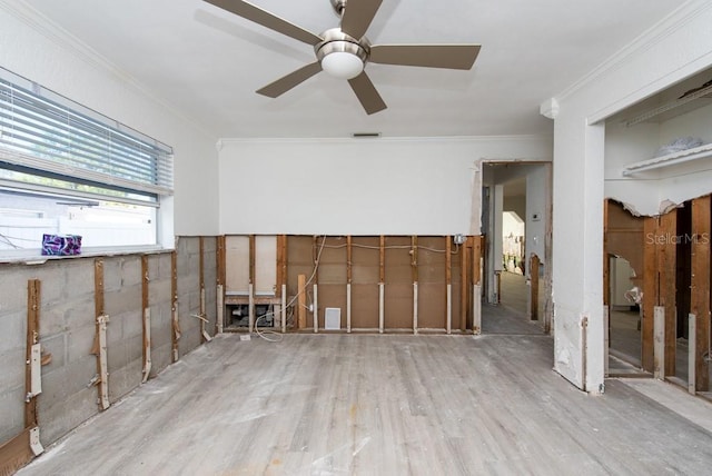 empty room with ceiling fan, ornamental molding, and light hardwood / wood-style flooring