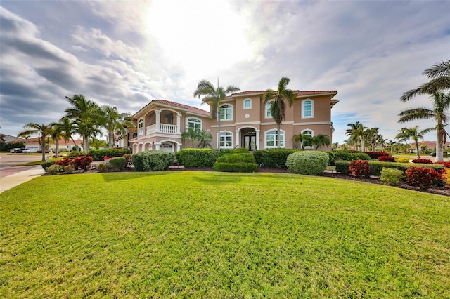 mediterranean / spanish house with a front lawn and a balcony