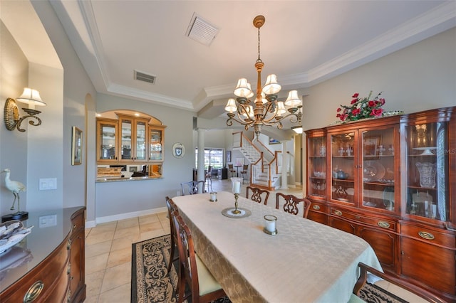 tiled dining room with ornate columns, crown molding, and an inviting chandelier