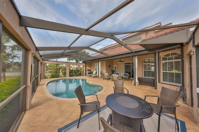 view of swimming pool featuring ceiling fan, a lanai, and a patio area