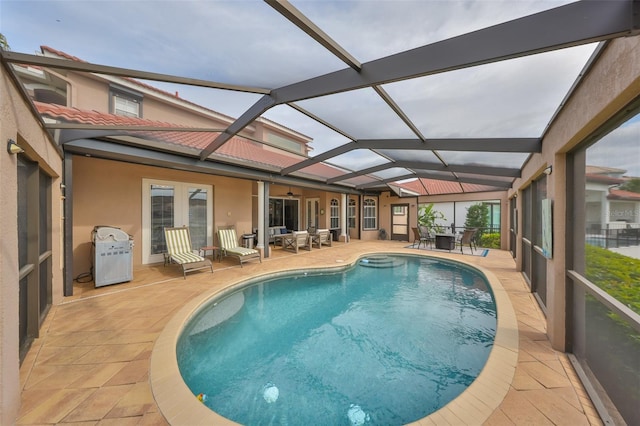 view of swimming pool featuring a patio and a lanai