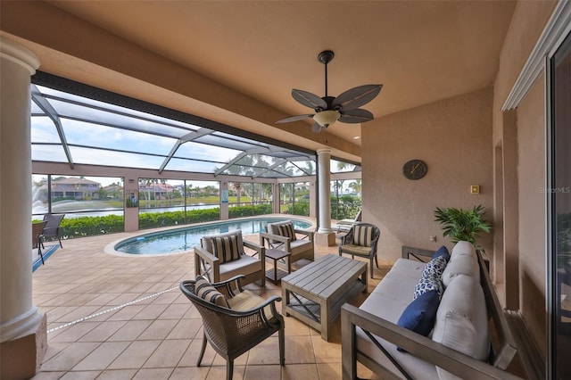 view of patio / terrace with a water view, ceiling fan, a lanai, and an outdoor hangout area