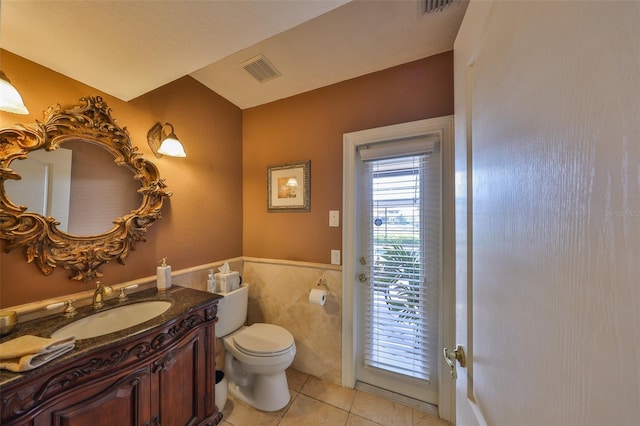 bathroom featuring vanity, tile patterned floors, tile walls, and toilet