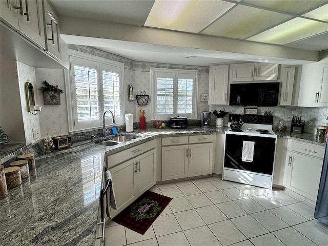 kitchen featuring sink, white cabinetry, dark stone countertops, range with electric cooktop, and light tile patterned flooring