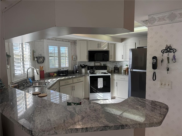 kitchen with sink, refrigerator, white cabinetry, electric range, and kitchen peninsula