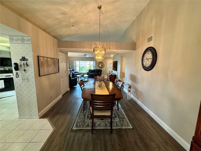 dining area featuring lofted ceiling, dark hardwood / wood-style flooring, and ceiling fan with notable chandelier