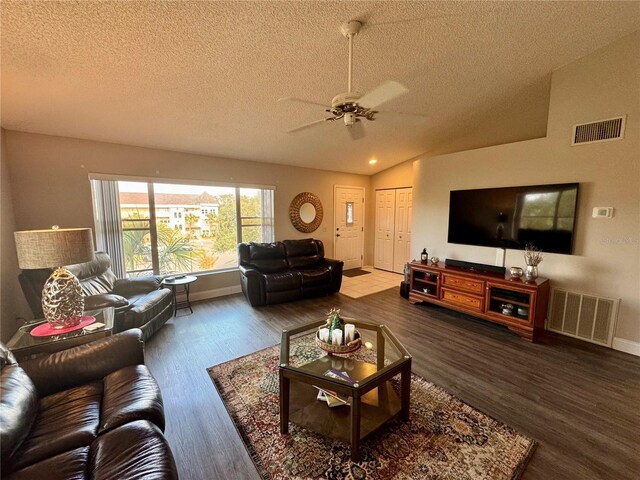 living room featuring hardwood / wood-style flooring, ceiling fan, vaulted ceiling, and a textured ceiling