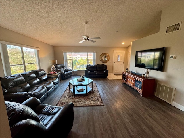 living room featuring ceiling fan, vaulted ceiling, dark hardwood / wood-style floors, and a textured ceiling