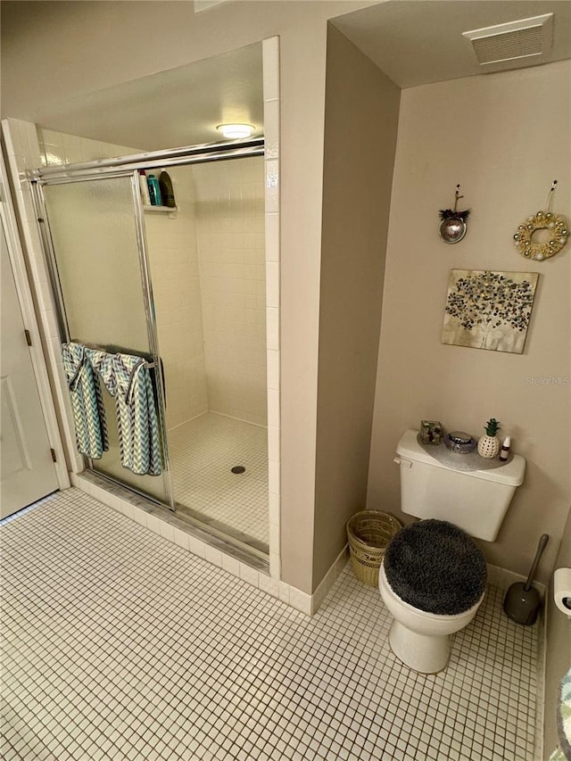 bathroom with tile patterned flooring, an enclosed shower, and toilet