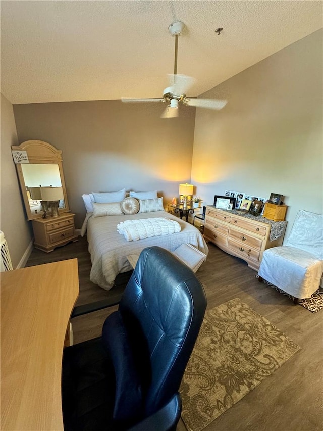 bedroom featuring ceiling fan, vaulted ceiling, dark hardwood / wood-style floors, and a textured ceiling