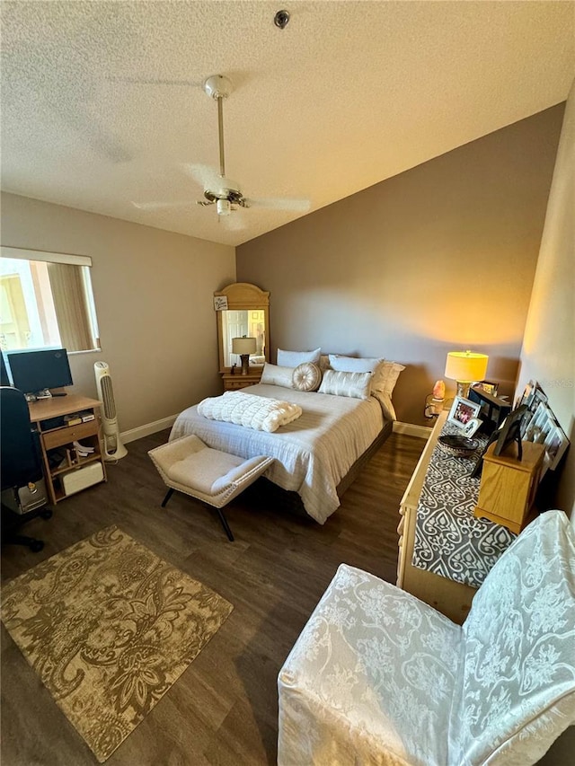 bedroom with vaulted ceiling, ceiling fan, a textured ceiling, and dark hardwood / wood-style flooring