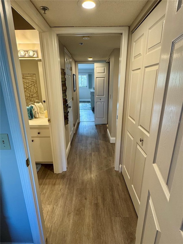 hall with dark hardwood / wood-style floors and a textured ceiling