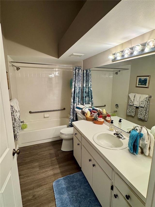 full bathroom featuring vanity, hardwood / wood-style floors, shower / bathtub combination with curtain, and toilet