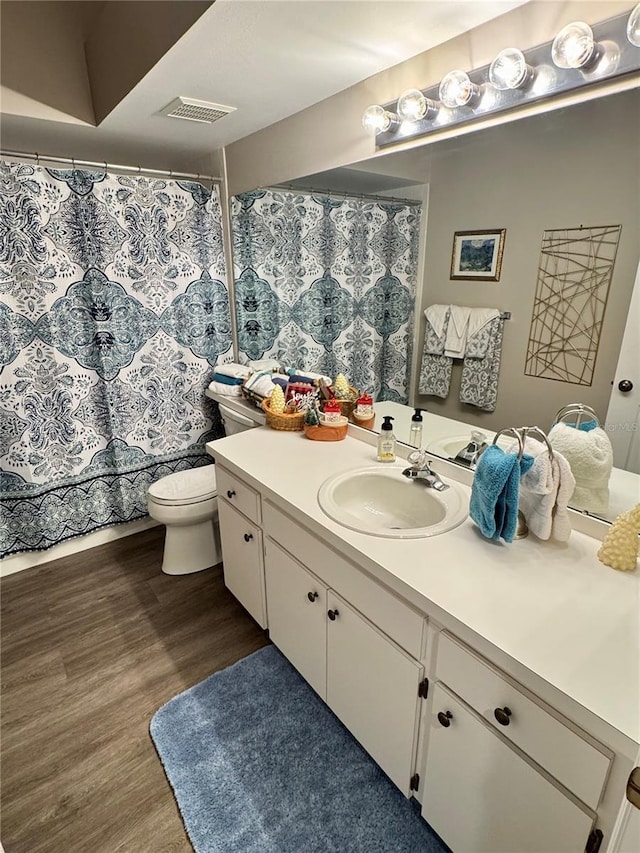 bathroom featuring vanity, wood-type flooring, and toilet