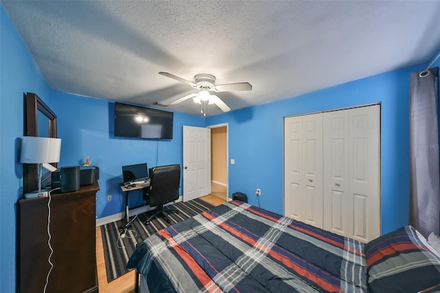 bedroom with ceiling fan, a closet, and a textured ceiling