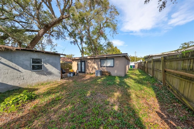 back of property with a lawn and central air condition unit