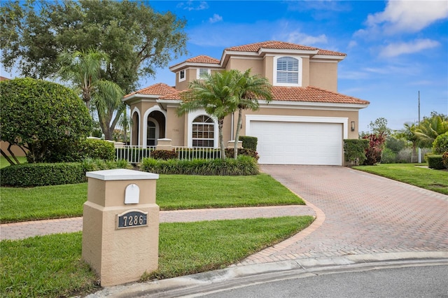 mediterranean / spanish-style house featuring a porch, a garage, and a front yard