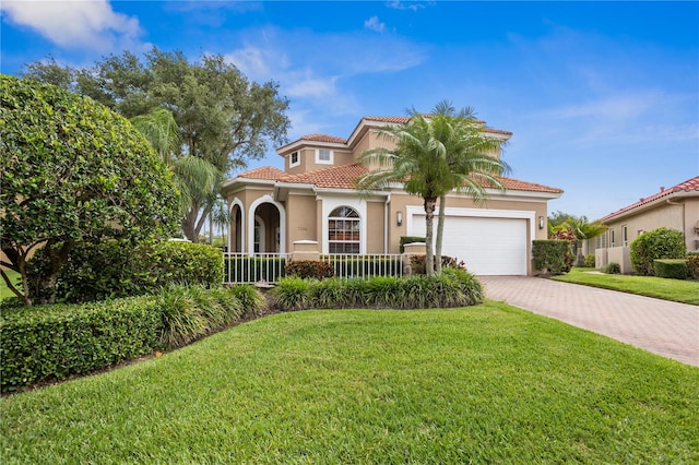 mediterranean / spanish house with a front yard and a garage