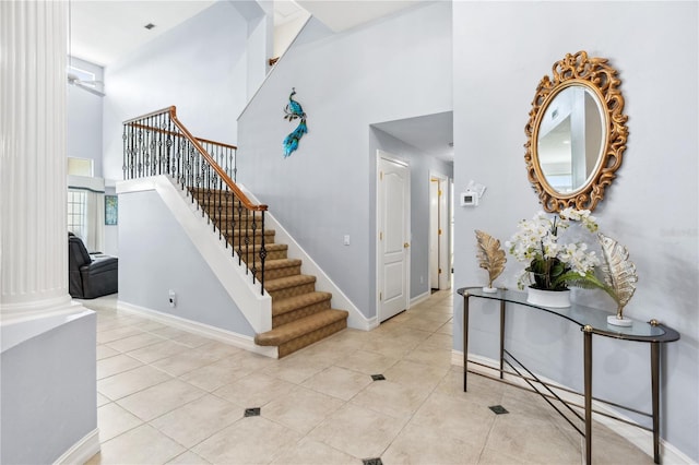 stairs with tile patterned flooring and a high ceiling