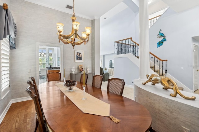 dining space featuring a chandelier, a high ceiling, hardwood / wood-style flooring, and crown molding