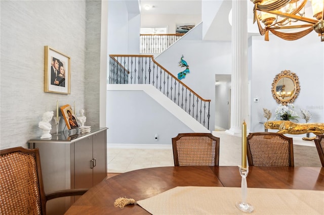 dining room featuring light tile patterned floors, a high ceiling, and a chandelier