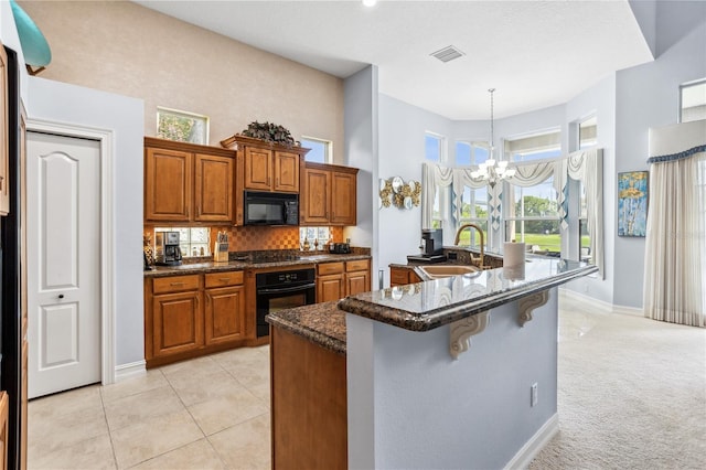 kitchen featuring sink, a wealth of natural light, a notable chandelier, and black appliances