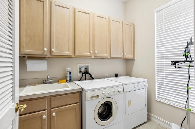 clothes washing area featuring sink, cabinets, and independent washer and dryer