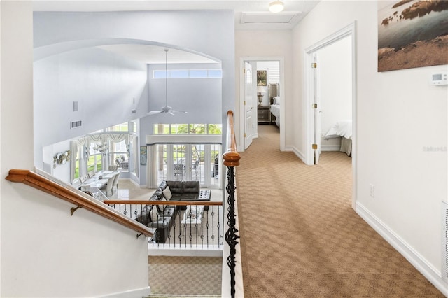 stairway featuring carpet, ceiling fan, and a towering ceiling