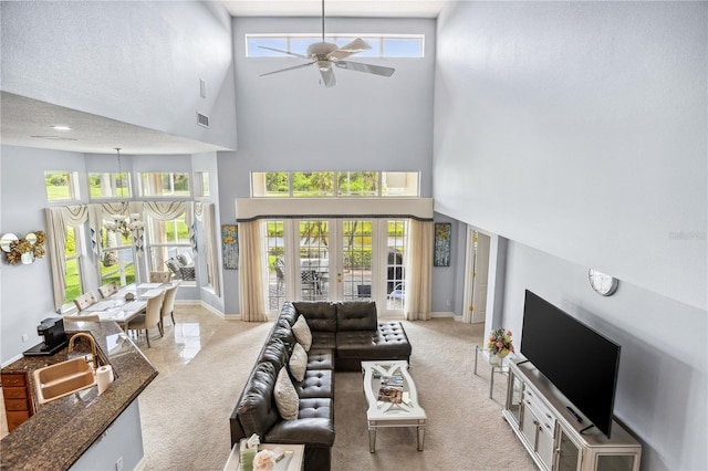 living room featuring a high ceiling, a healthy amount of sunlight, and sink