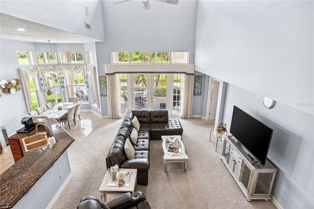 living room with a textured ceiling, sink, a high ceiling, and a wealth of natural light