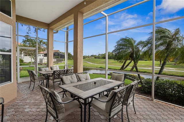 sunroom featuring a water view