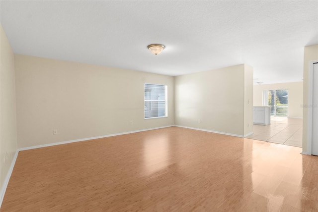 empty room featuring a textured ceiling and light wood-type flooring