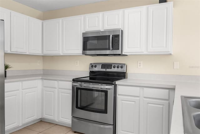 kitchen featuring white cabinets, stainless steel appliances, and light tile patterned floors