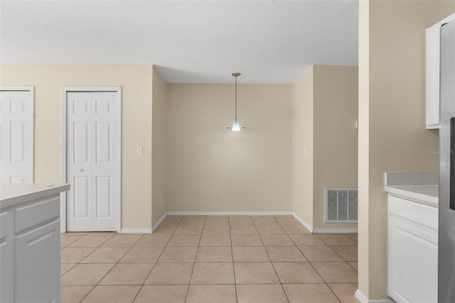 empty room with light tile patterned floors and a textured ceiling