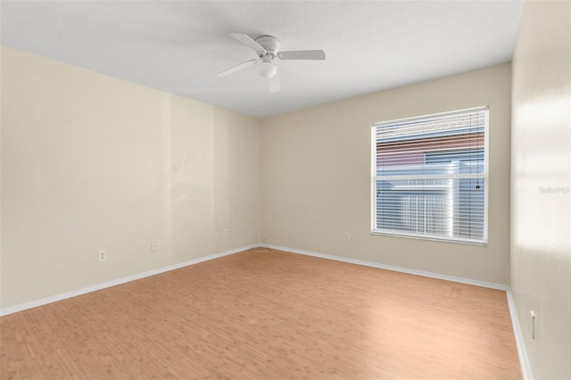 empty room with ceiling fan and light hardwood / wood-style flooring