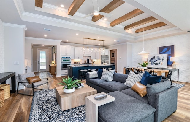 living room featuring light hardwood / wood-style flooring, ceiling fan, and ornamental molding