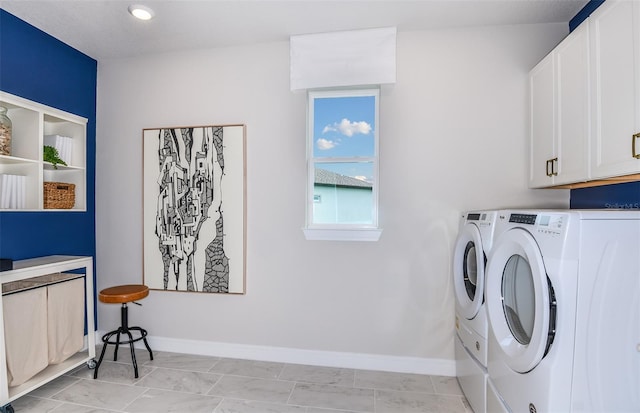 clothes washing area featuring washer and dryer, cabinets, and light tile patterned floors