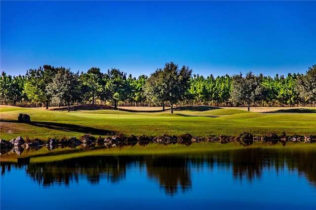 surrounding community with a water view and a yard