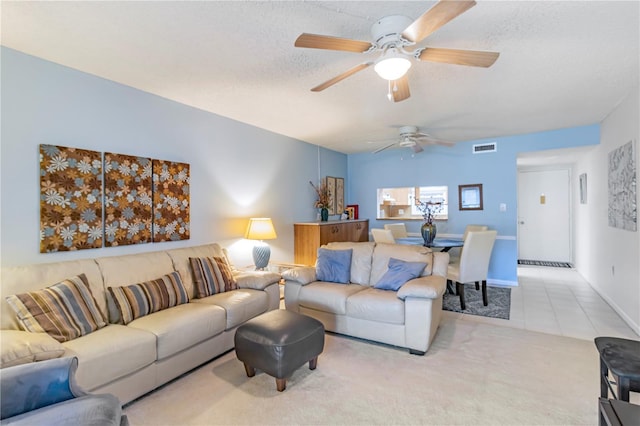 carpeted living room with ceiling fan and a textured ceiling