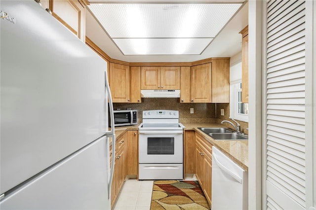 kitchen featuring sink, light tile patterned floors, and white appliances