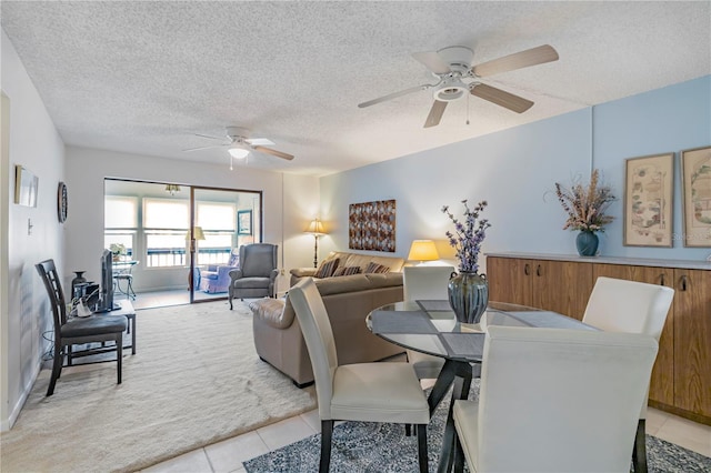 dining space featuring light tile patterned floors, a textured ceiling, ceiling fan, and wooden walls