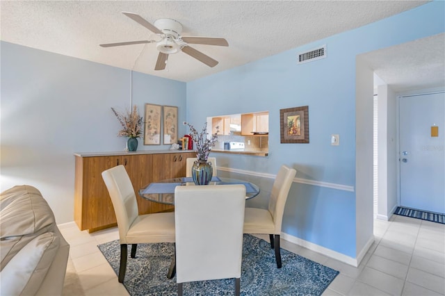 tiled dining space featuring ceiling fan and a textured ceiling