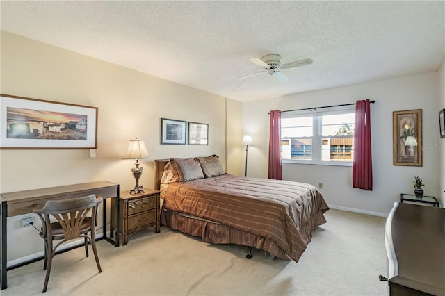 carpeted bedroom featuring ceiling fan and a textured ceiling